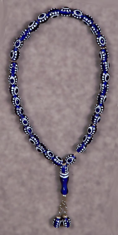 A tasbih with blue, oval beads painted with wihite details to look like eyes or nazaars.