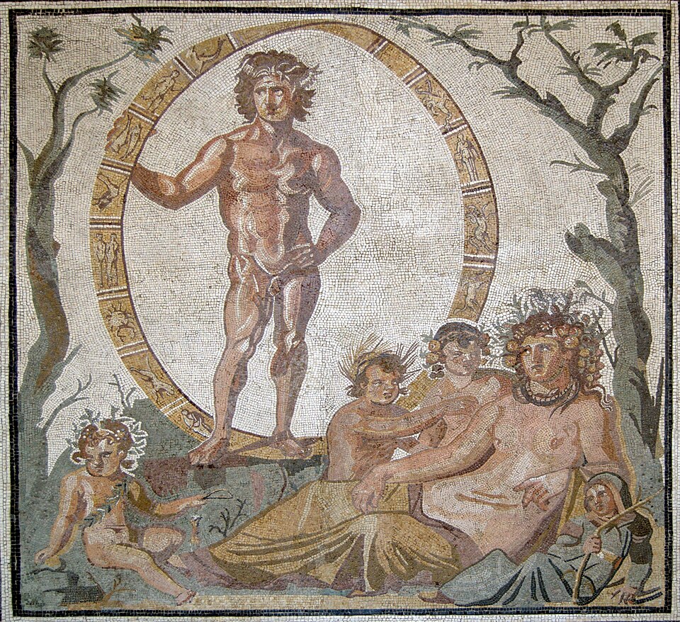 A Roman mosaic of a bronze, muscular young man standing nude and contrapposto with one hand on His hip and the other holding the wheel of the zodiac. Beneath Him is Gaia reclining on the ground, surrounded with baby children and with Her head adorned by the fruits of the Earth.